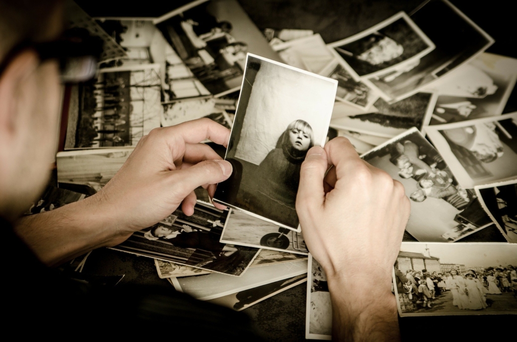 Man holding black and white prints in his hands